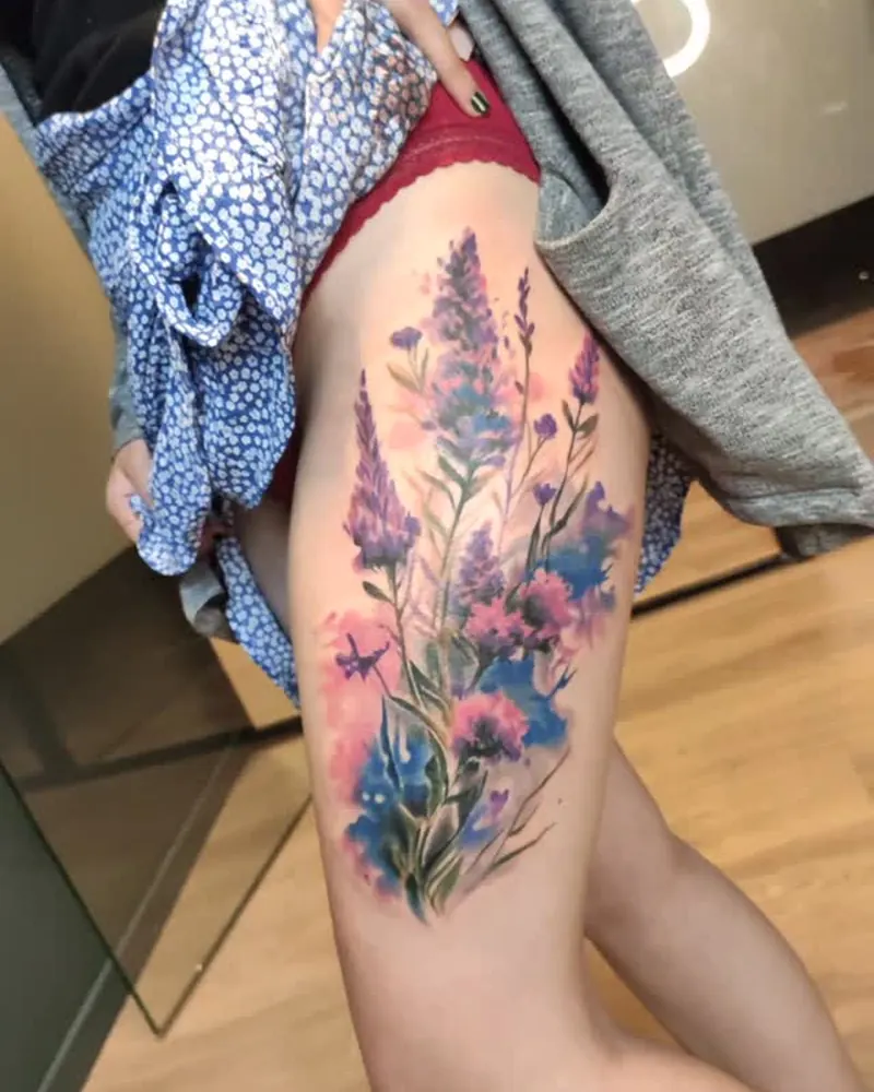 Blomstertatovering i farge på lår